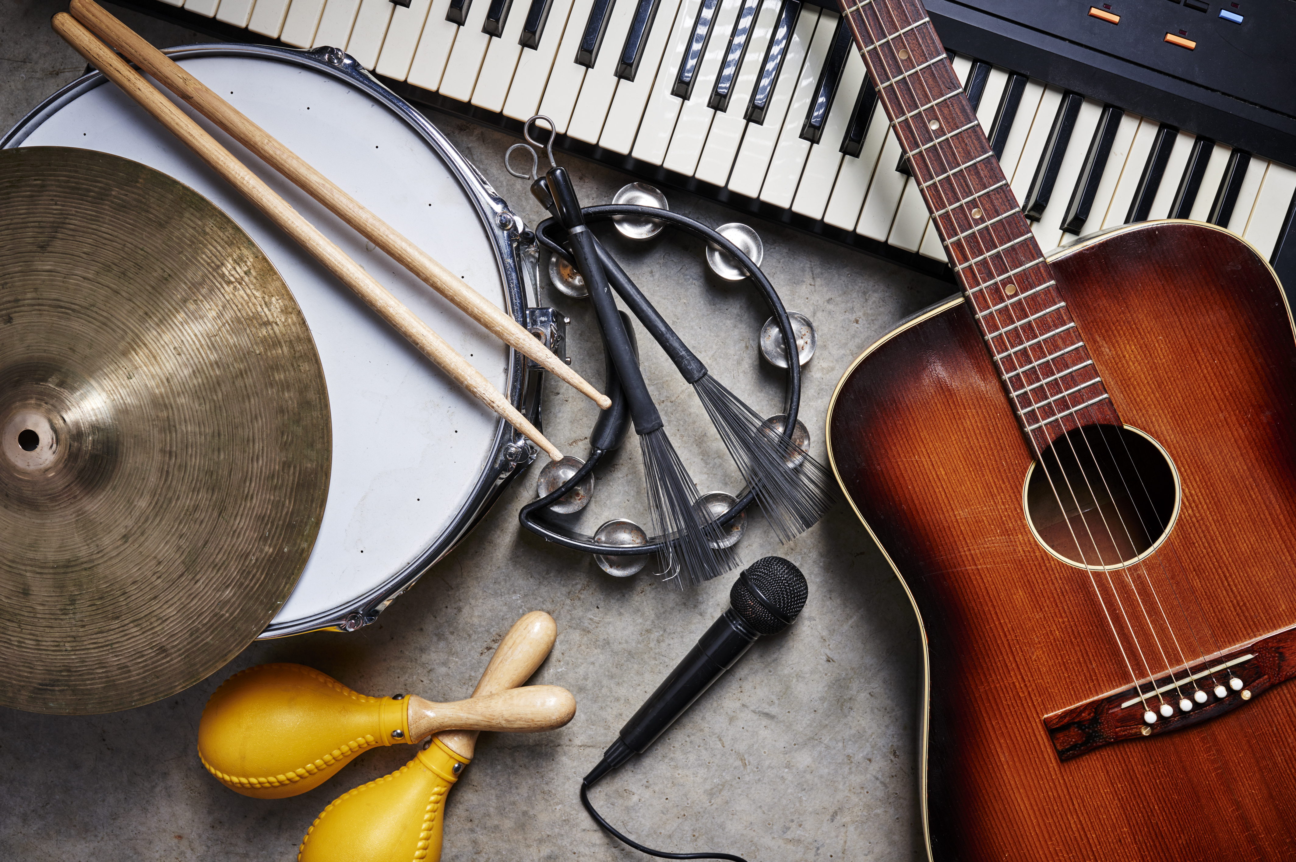 Various instruments laid out on floor including symbols, drum, keyboard, microphone, and guitar