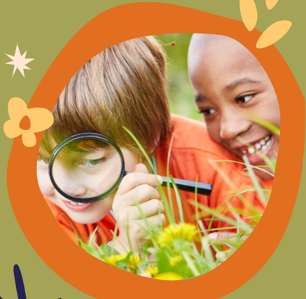 two children using a magnifying glass to look at flowers