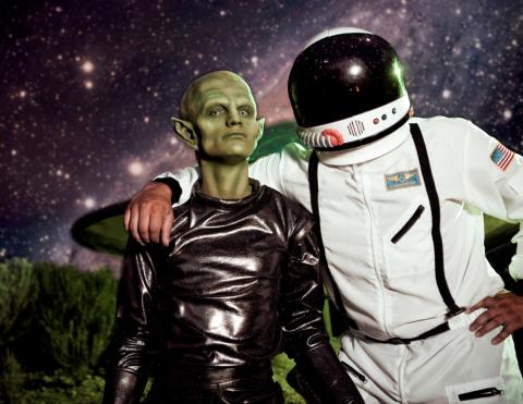 photograph of green alien with astronaut
